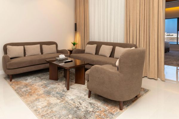 Cozy living room with brown sofas, a wooden coffee table, and a patterned rug.