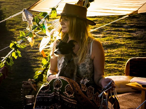 Zoe Armstrong business owner sitting looking at ocean with a small dog on her lap (Pony)