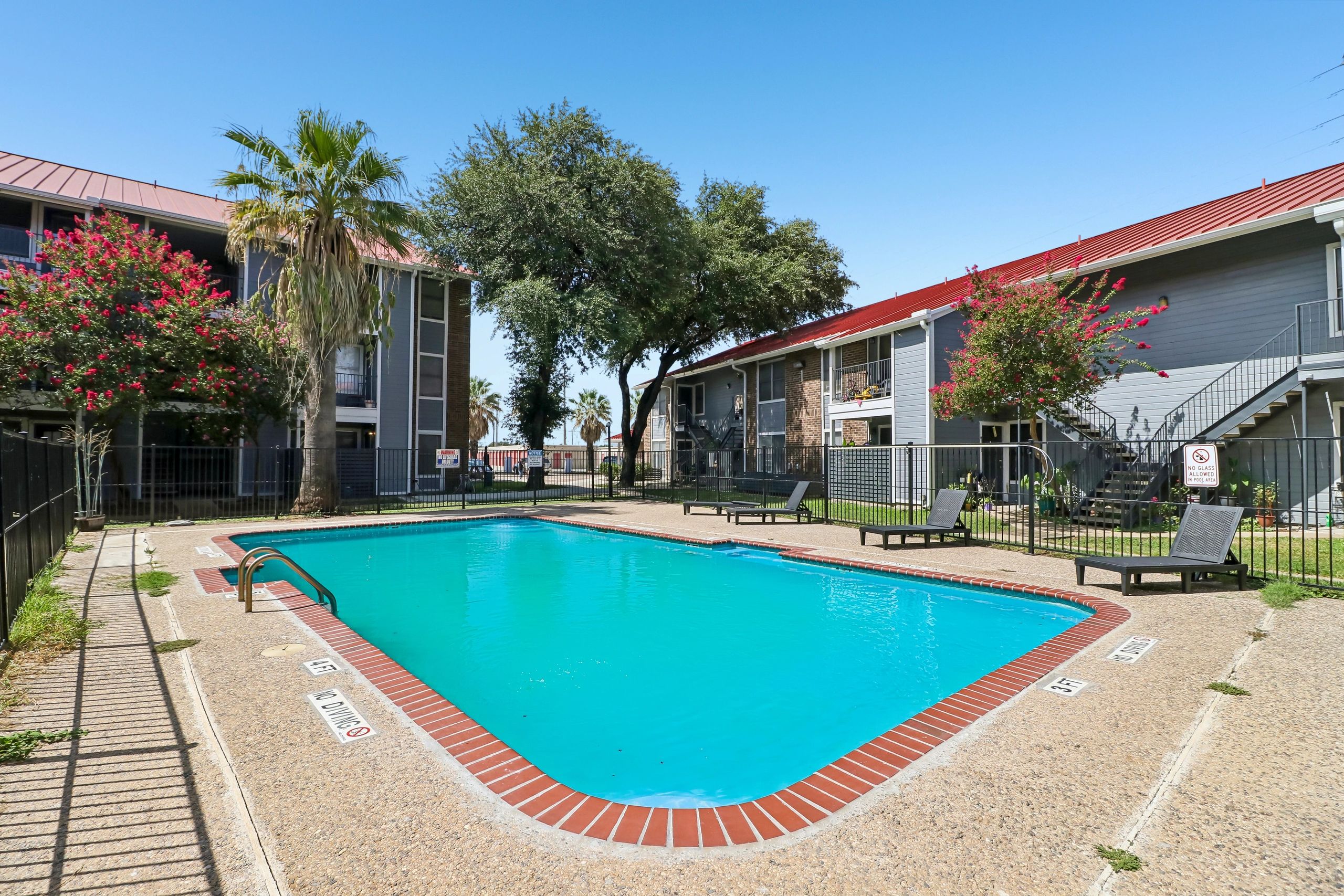 Outdoor swimming pool between apartment buildings on a sunny day.