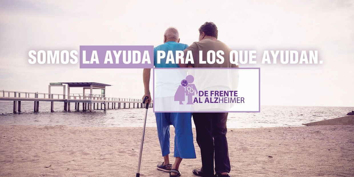 Two people walking on the beach, supporting each other, with a message about helping Alzheimer's caregivers.