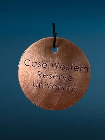 Copper round tag with "Case Western Reserve University" engraving.