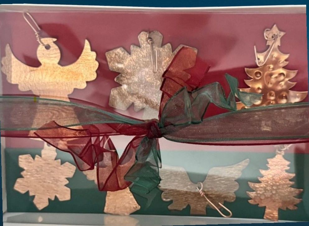 Christmas-themed metal ornaments tied with red and green ribbons.