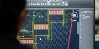 Person viewing architectural CAD design on computer screen.