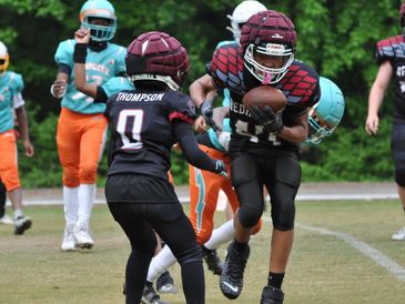 Youth football players in action on the field.
