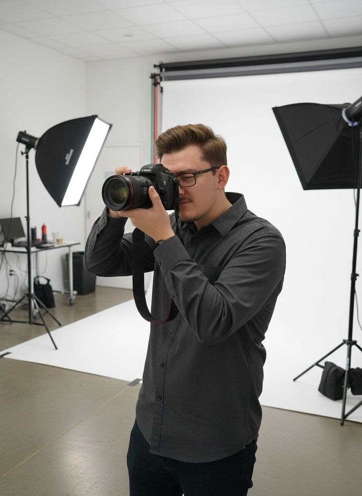 Photographer taking a photo in a professional studio setup.