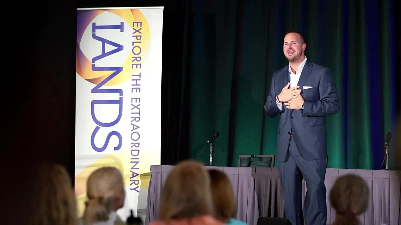 Chase Skylar DeMayo speaking onstage at an IANDS conference.
