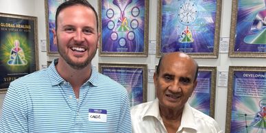 Two men holding a colorful creativity certificate in a room with framed posters.