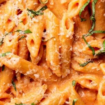 Creamy penne pasta with tomato sauce and fresh basil.
