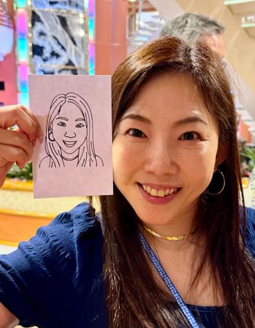 Woman holding a drawing of her face.