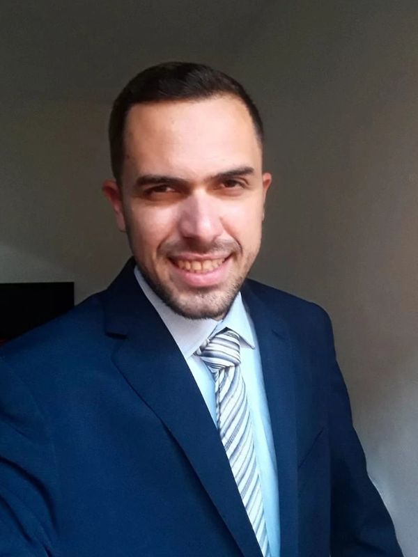 Homem sorridente de terno azul.