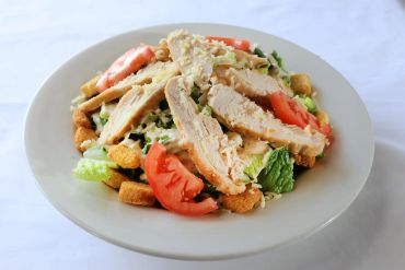 Chicken Caesar salad with croutons and tomatoes.