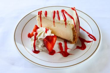 Cheesecake slice with strawberries and whipped cream.