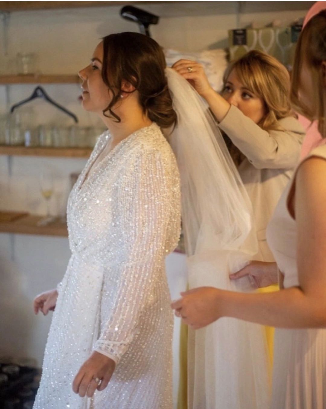 hairstylist adding veil to brides hair