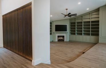 custom slat wall made of solid maple with recessed integral LED lighting, with custom library behind