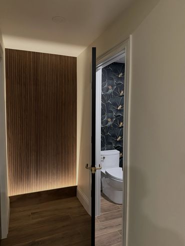 walnut accent wall with integral lighting in baseboard giving the glow effect