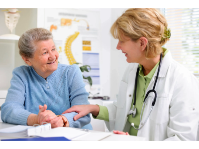 Happy respite-stay senior conversing with compassionate medical professional