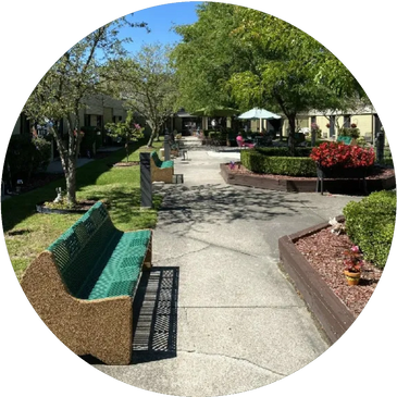 A view of the Beechwood Manor courtyard with benches and three raised garden beds in the center.