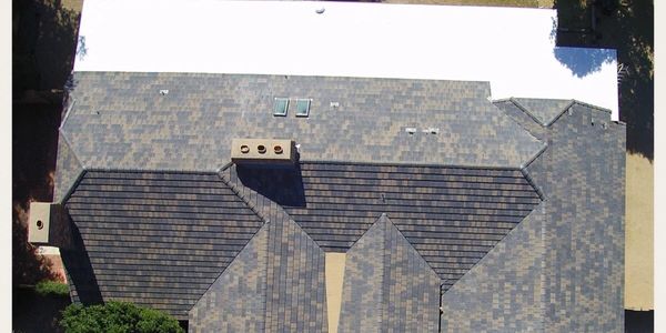 Before and After picture on a Shake Roof replaced with a Concrete Tile Roof and Foam Roof System