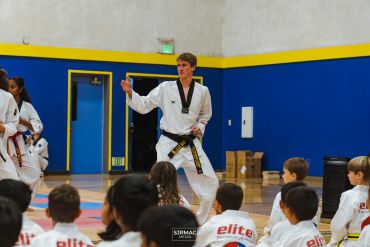 Taekwondo instructor teaching students in a gym.