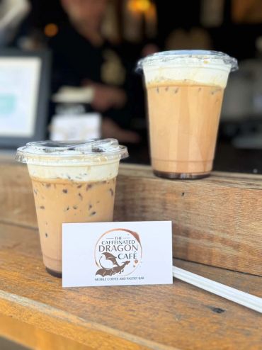 Two iced coffee drinks with a café business card.