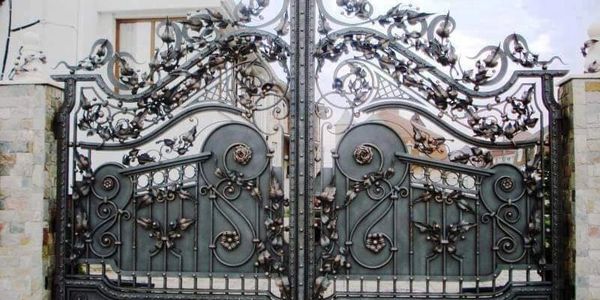 Intricate wrought iron gate with floral and scroll designs.