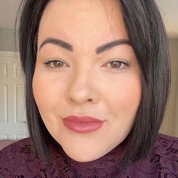 Close-up of a woman with straight dark hair and neutral makeup.