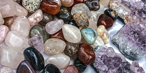 A collection of polished and raw gemstones in various colors and shapes.