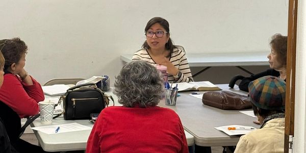 A group of people engaged in a discussion around a table.