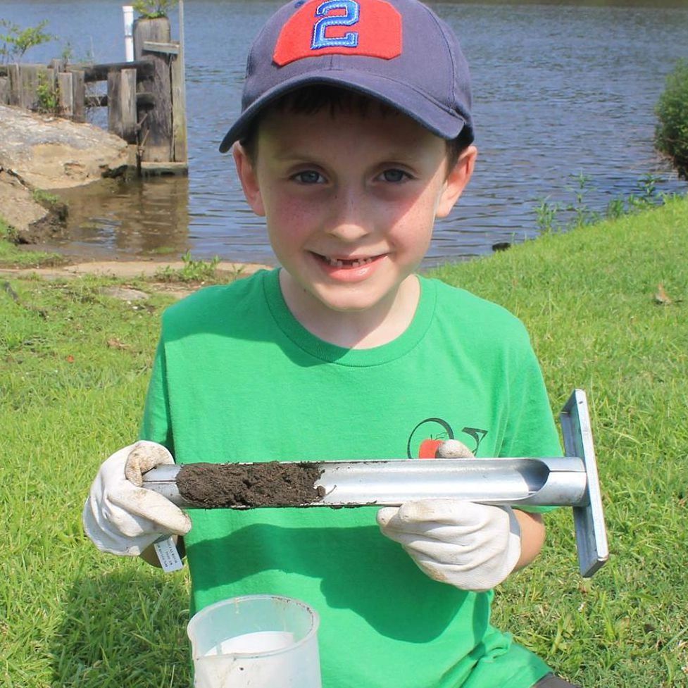 A small boy playing with pipe