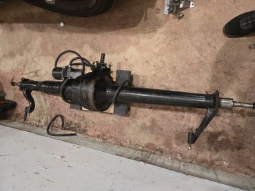 Black steering column with wiring and mounting bracket.