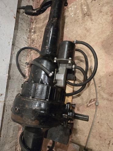 Black mechanical part with attached motor and cables.