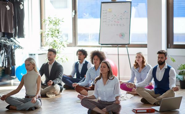 Group of people practicing mindfulness or meditation in a bright room