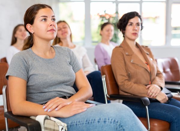 Focused woman attending a wellness seminar with others