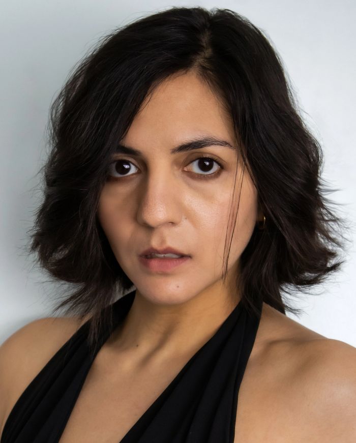 Close-up portrait of a woman with dark hair and intense eyes.