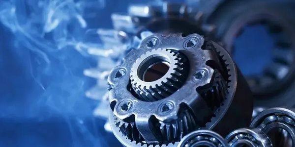 Close-up of a metallic gear mechanism with smoke in the background.