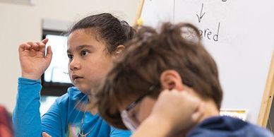 Two children attentively participating in a classroom activity.