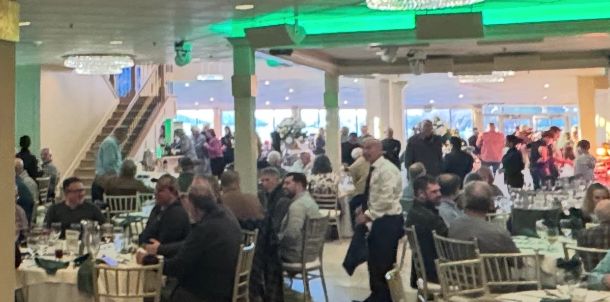 A crowded banquet hall with people dining and socializing.