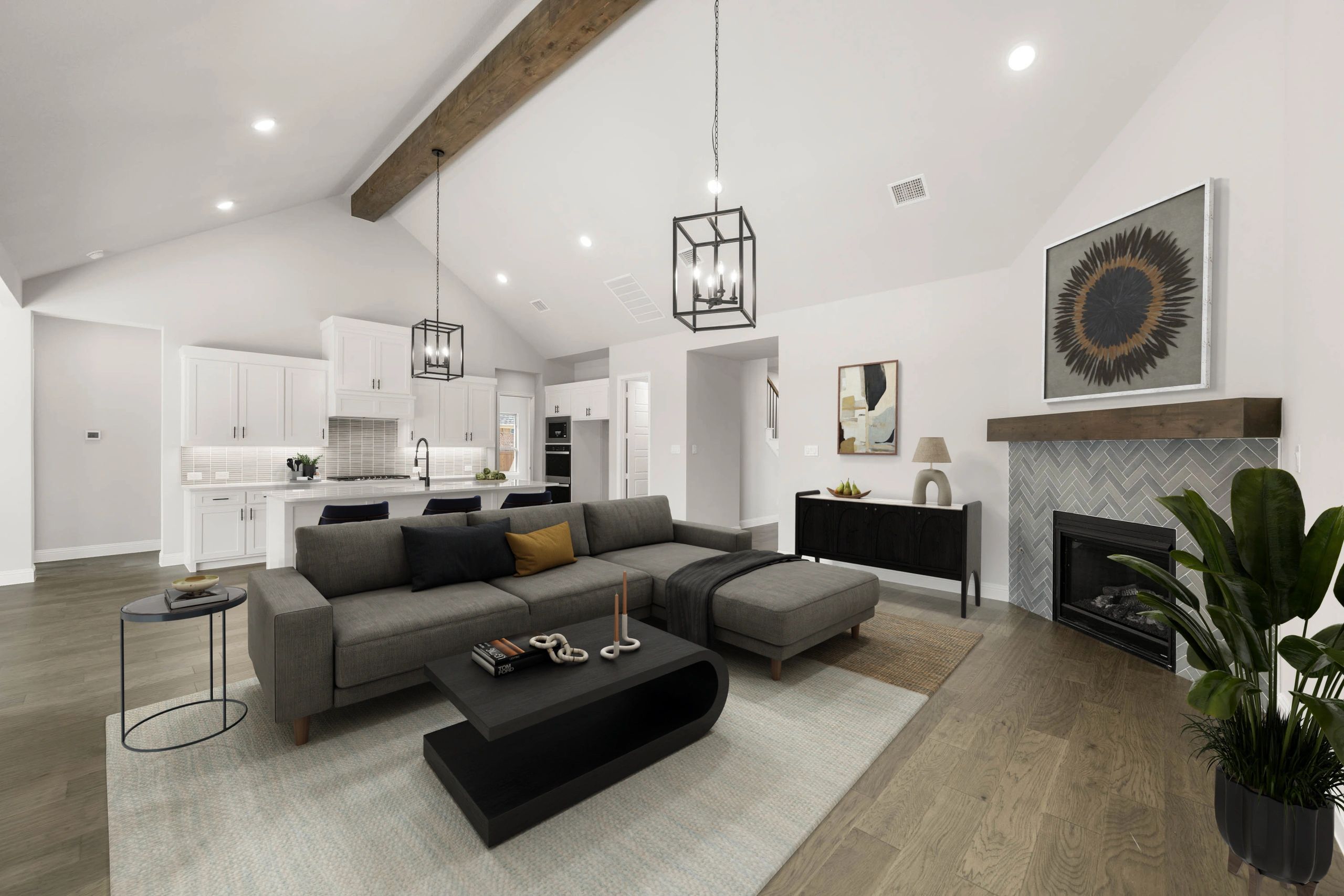 Modern living room with gray sectional, fireplace, and open kitchen design.