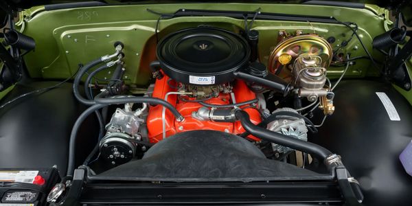 Clean and well-maintained car engine with an olive green background.
