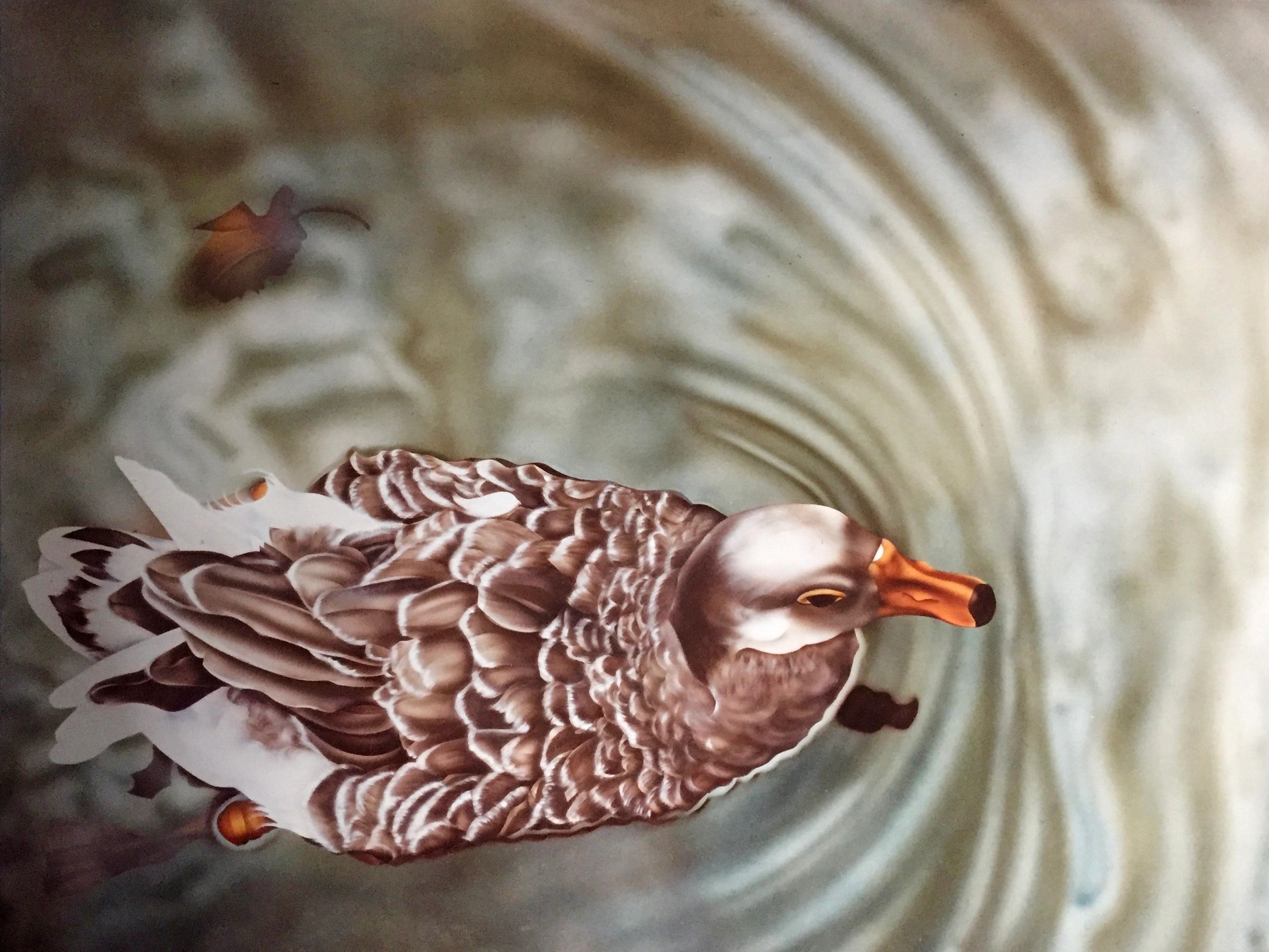 A duck swimming in water with ripples and a floating leaf.