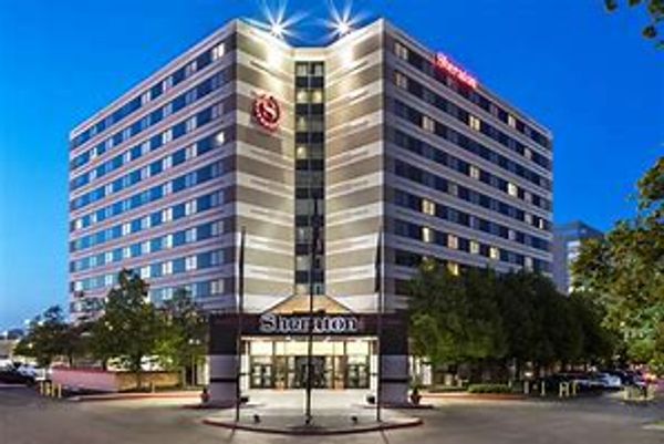 Exterior view of a Sheraton hotel building at dusk.