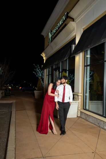 Walking hand in hand by the showroom at night, the city lights illuminate their happiness
