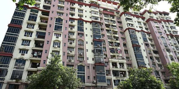 Tall residential building with many windows and balconies.