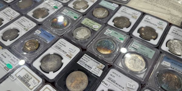 A collection of graded coins displayed in protective cases.