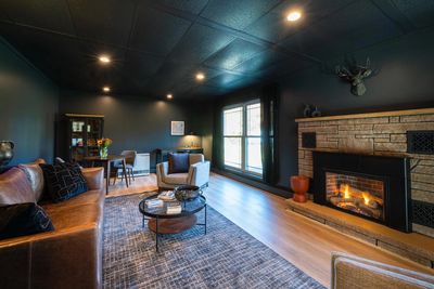 Cozy living room with fireplace and dark walls.