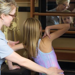 Dr. Stevens guiding a female client through Schroth method exercises.