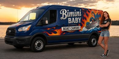 Woman standing beside a colorful Bimini Baby Boat Canvas van at sunset.