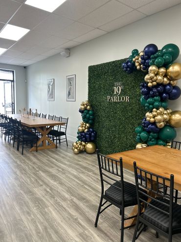 Interior of a stylish event space with greenery and balloon decor.