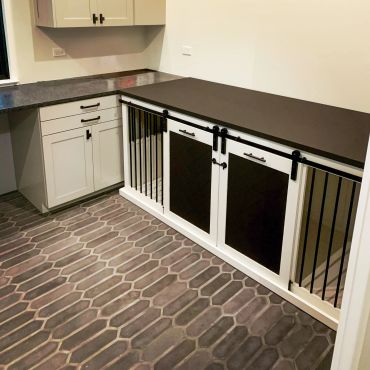 Modern pet gate with sliding doors in a kitchen corner with hexagonal tile flooring.