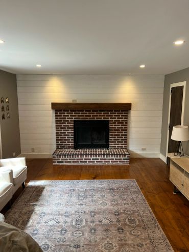 Cozy living room with brick fireplace and wooden floors.